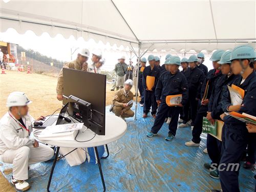 平成28年度　つるぎ高等学校　建設現場見学会　現場で高校生が熱心に話を聞く。